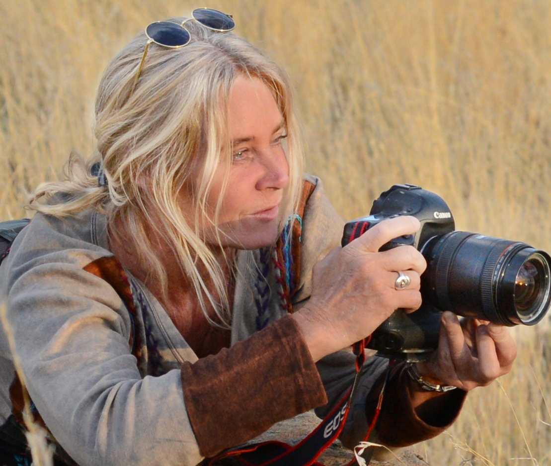 Jytte photographing with her camera in the golden grass