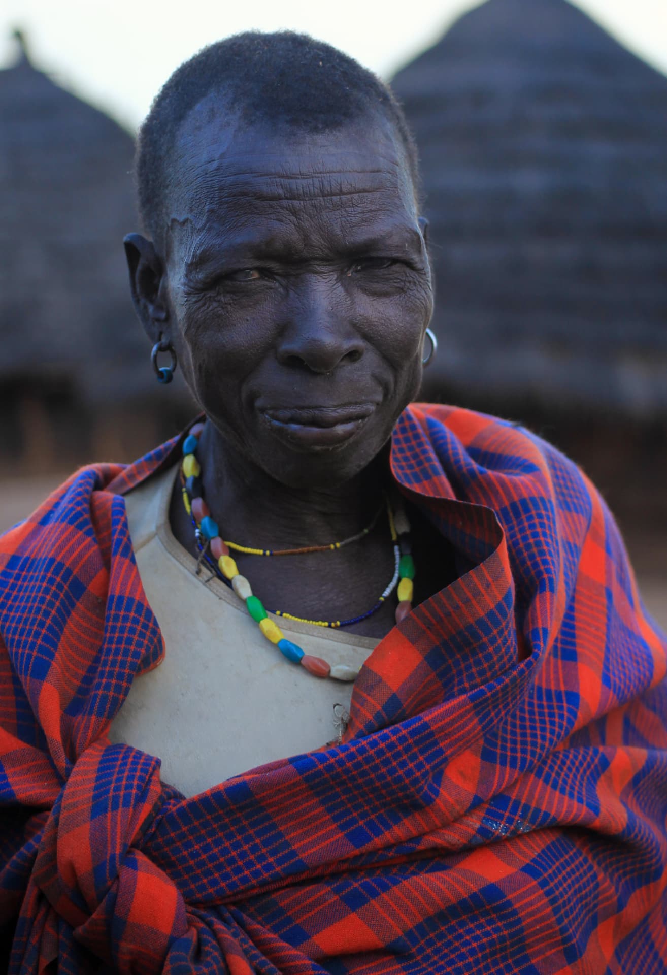 Lurukul woman wrapped in a red and blue blanket