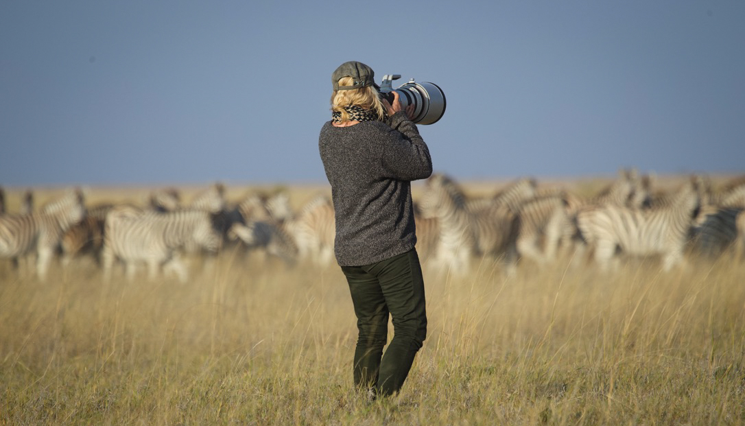 Jytte photographing a herd of zebras on the open plains